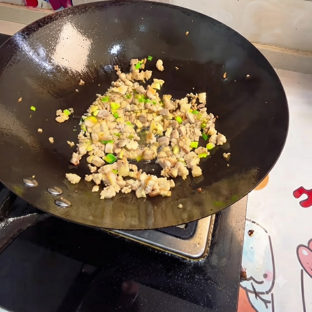 中華鍋でひき肉と香味野菜を炒め合わせている様子。