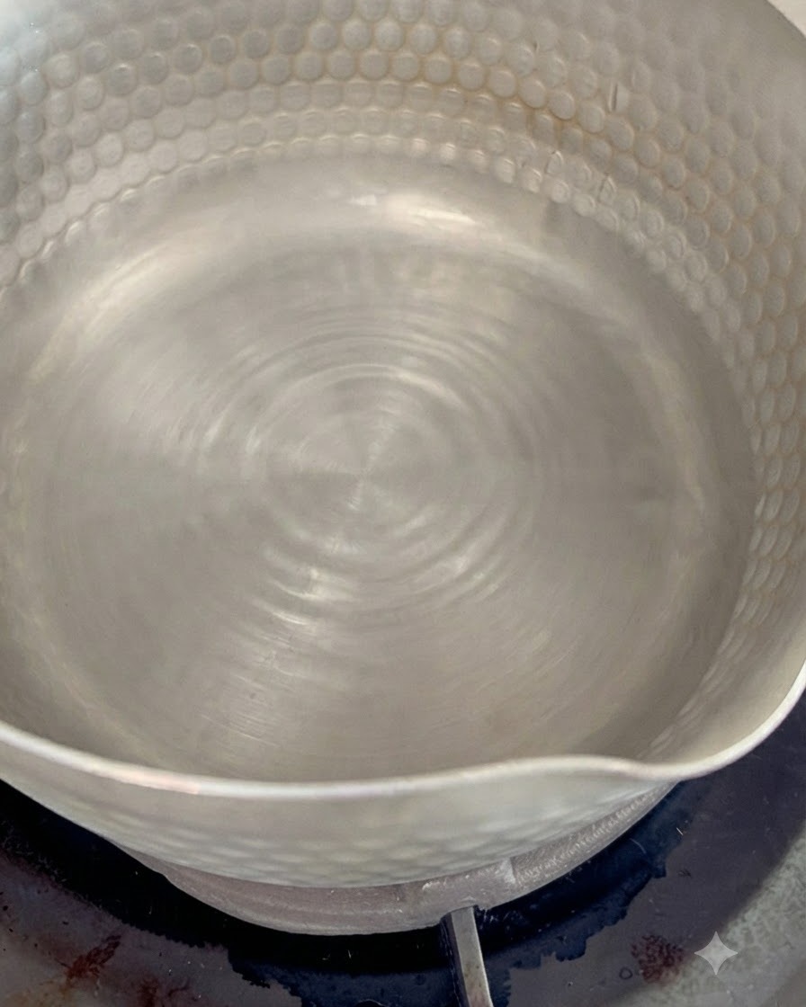 小鍋でお湯を沸かし、かつお節を入れて出汁をとっている様子