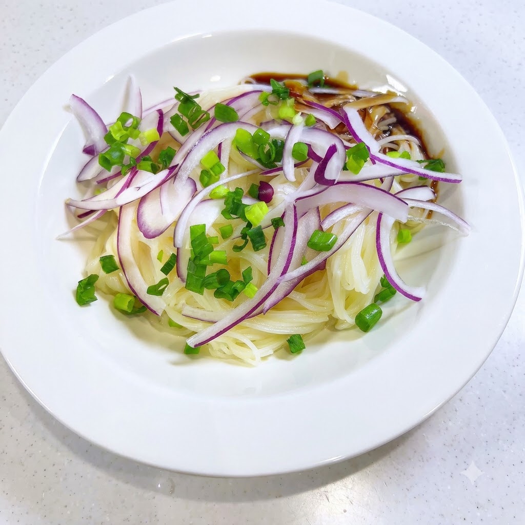 白い器の中のそうめんとトッピングの周りに、濃い色の特製つゆを注いでいる様子。