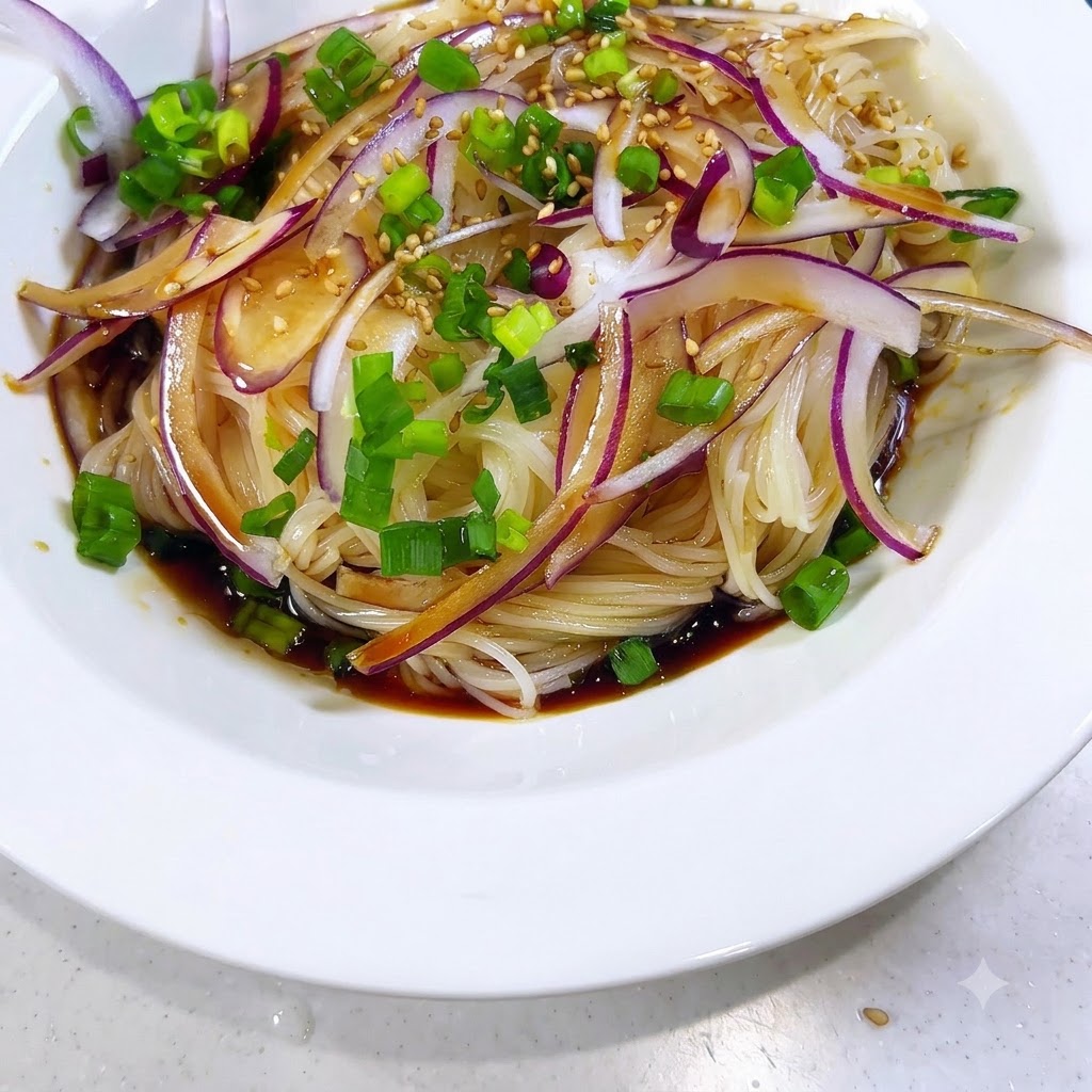 味付けされたそうめんとトッピングの上に、白ごまを散らしている様子。