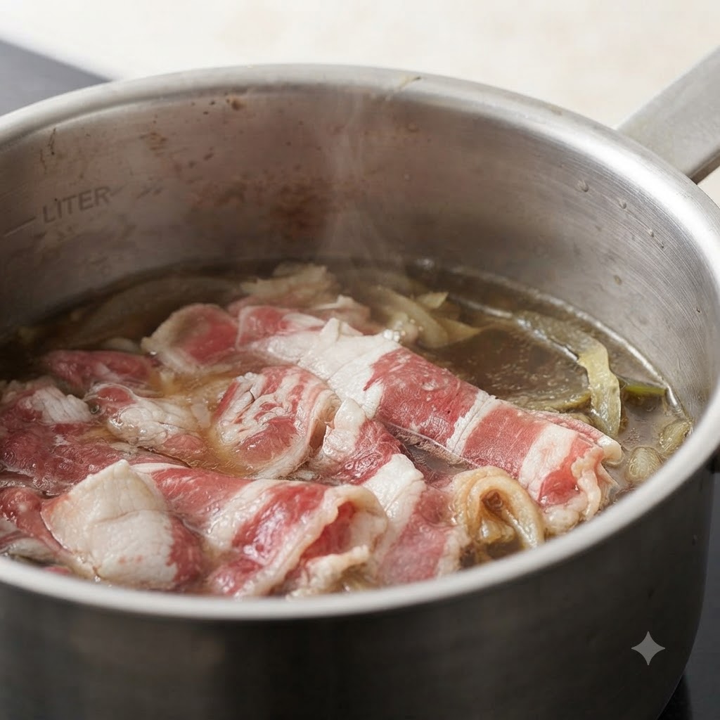 牛肉と玉ねぎが煮込まれている鍋に、みじん切りにした生姜を加えている様子。