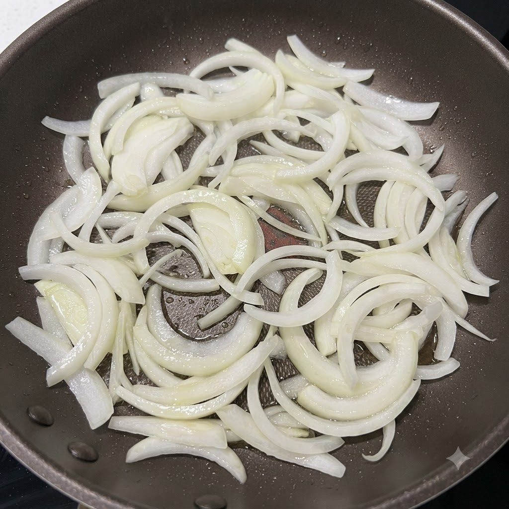 熱したフライパンで、縁がうっすらと色づくまで炒められる玉ねぎ。