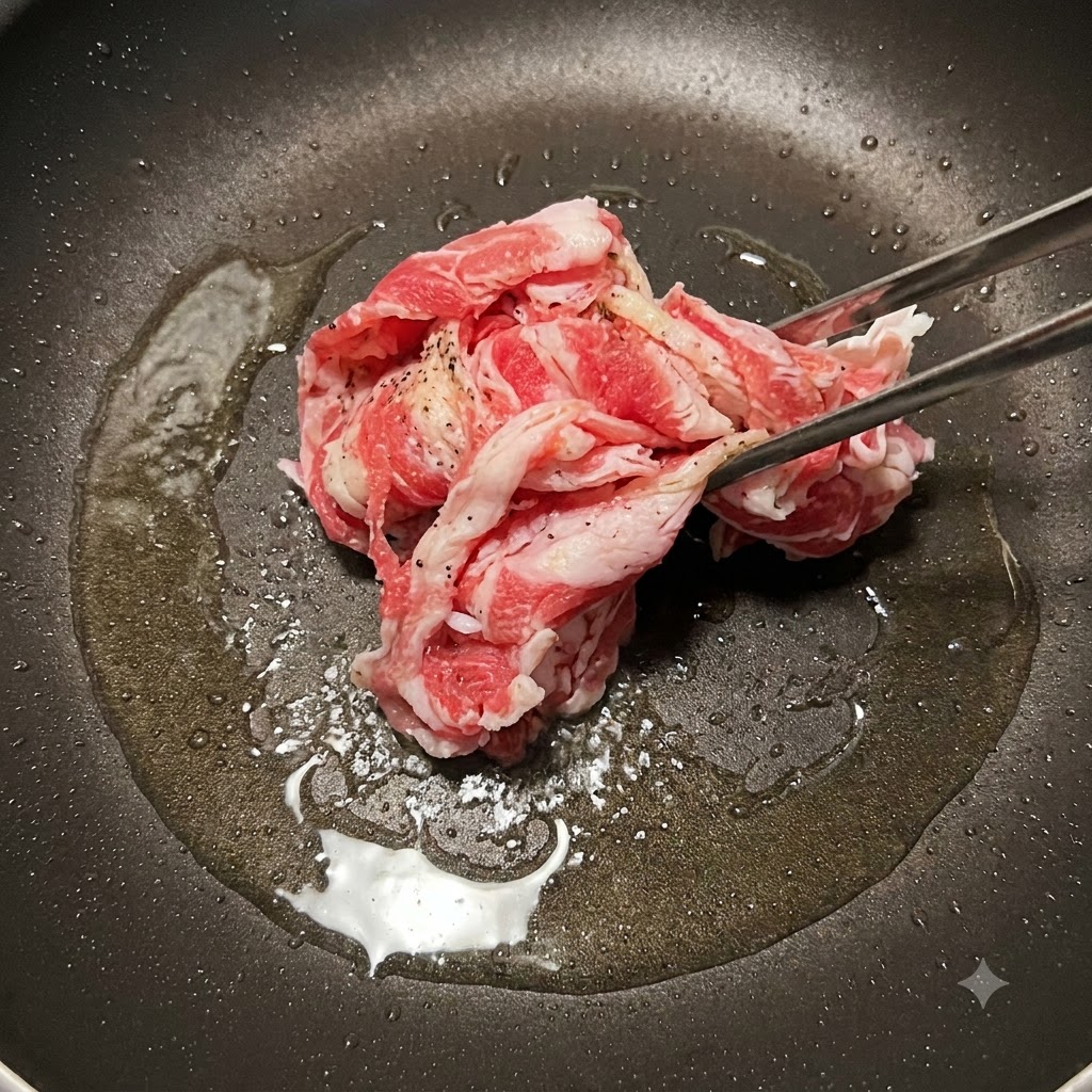 フライパンで焼き色がつくまで炒められる牛薄切り肉。