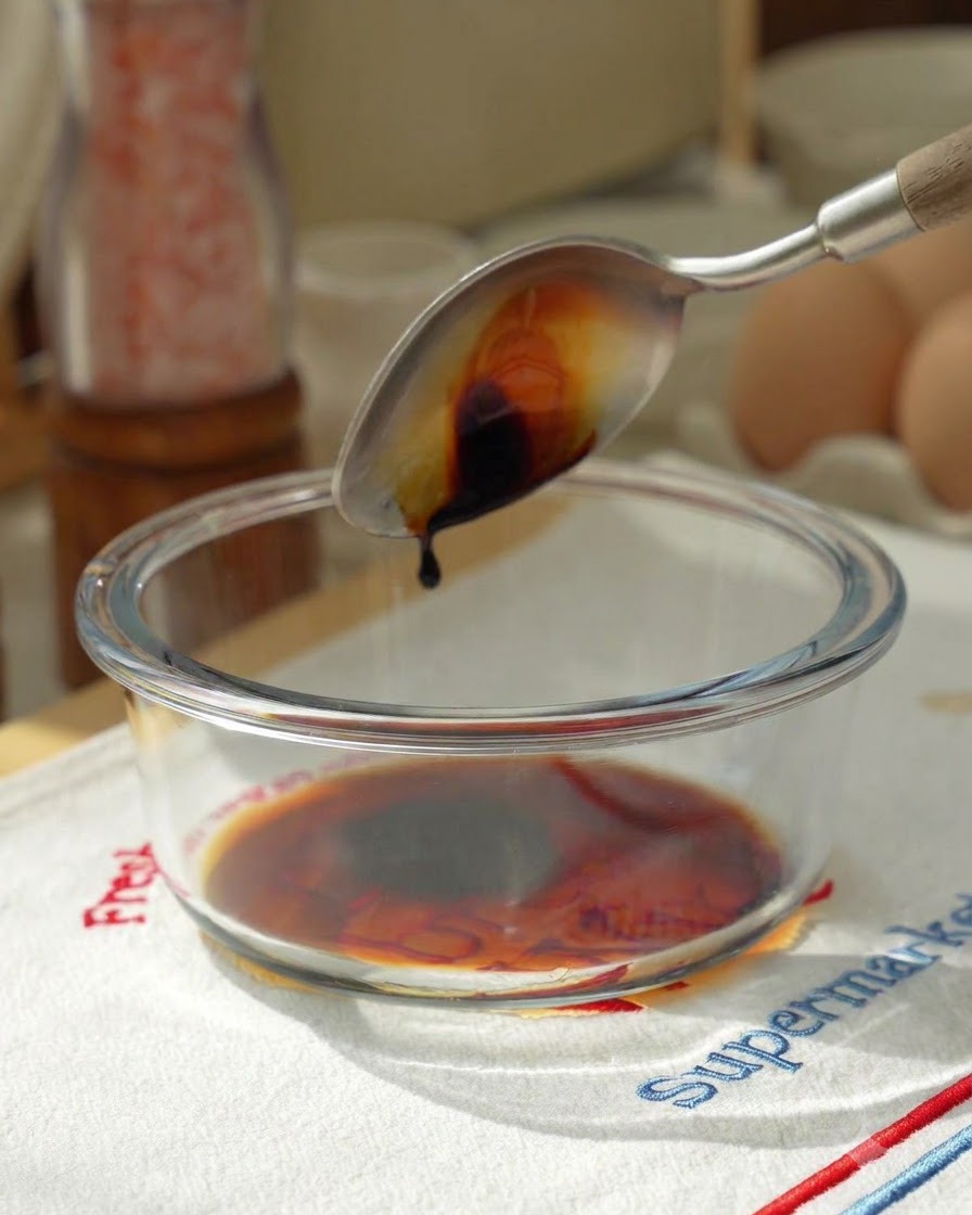 ガラスボウルに醤油や他の調味料を入れて混ぜている様子。