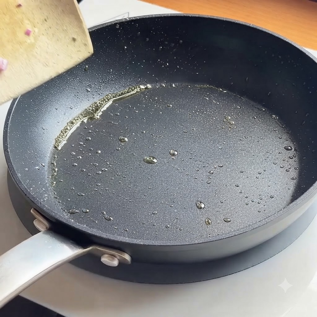 フライパンに油を引き、刻んだ赤玉ねぎをしんなりするまで炒めている様子。