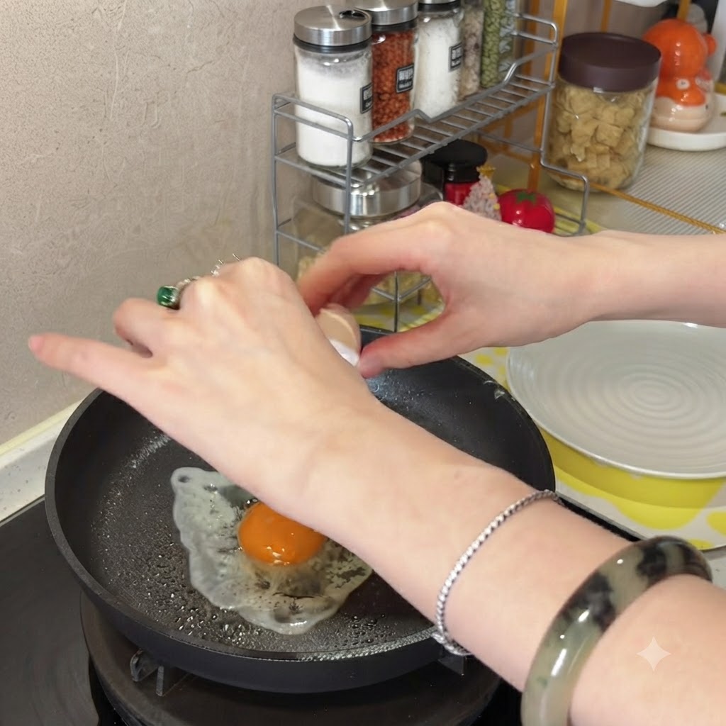 油を引いた熱したフライパンに卵を割り入れる様子。