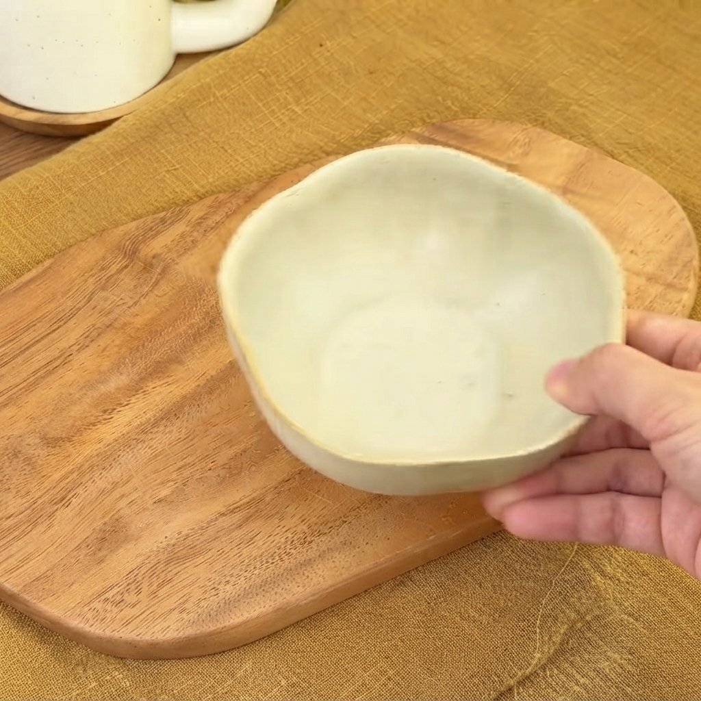 木製のまな板の上に置かれた、タレを混ぜるための空の小さなセラミック製ボウル。