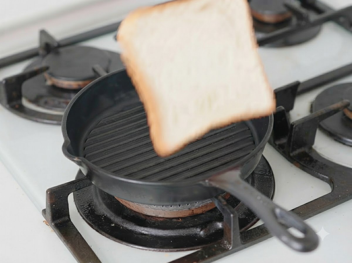 予熱した黒いグリルパンの中に置かれた、チーズがのった1枚の食パン。