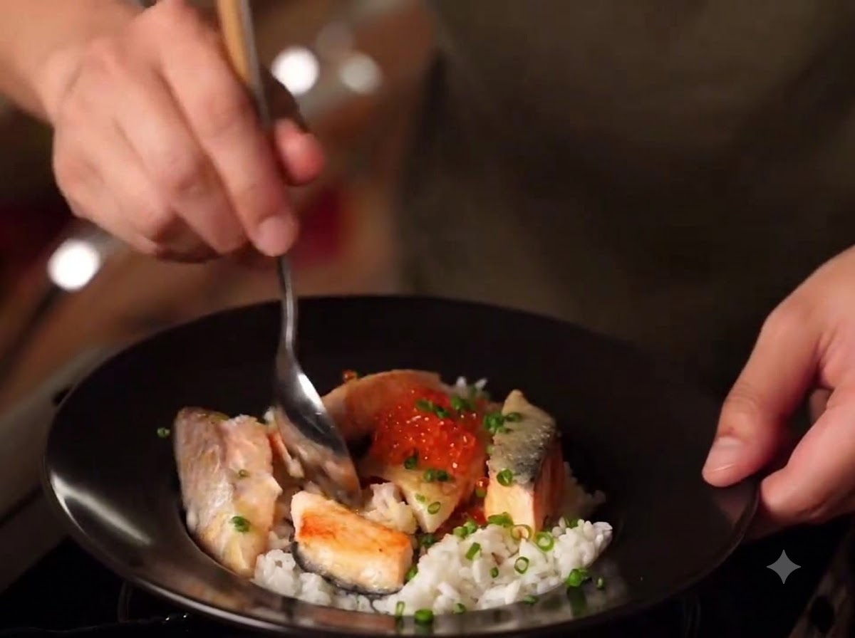 ご飯、ソテーしたサーモン、イクラ、青ネギが乗った味噌サーモン親子丼の完成品のクローズアップ。