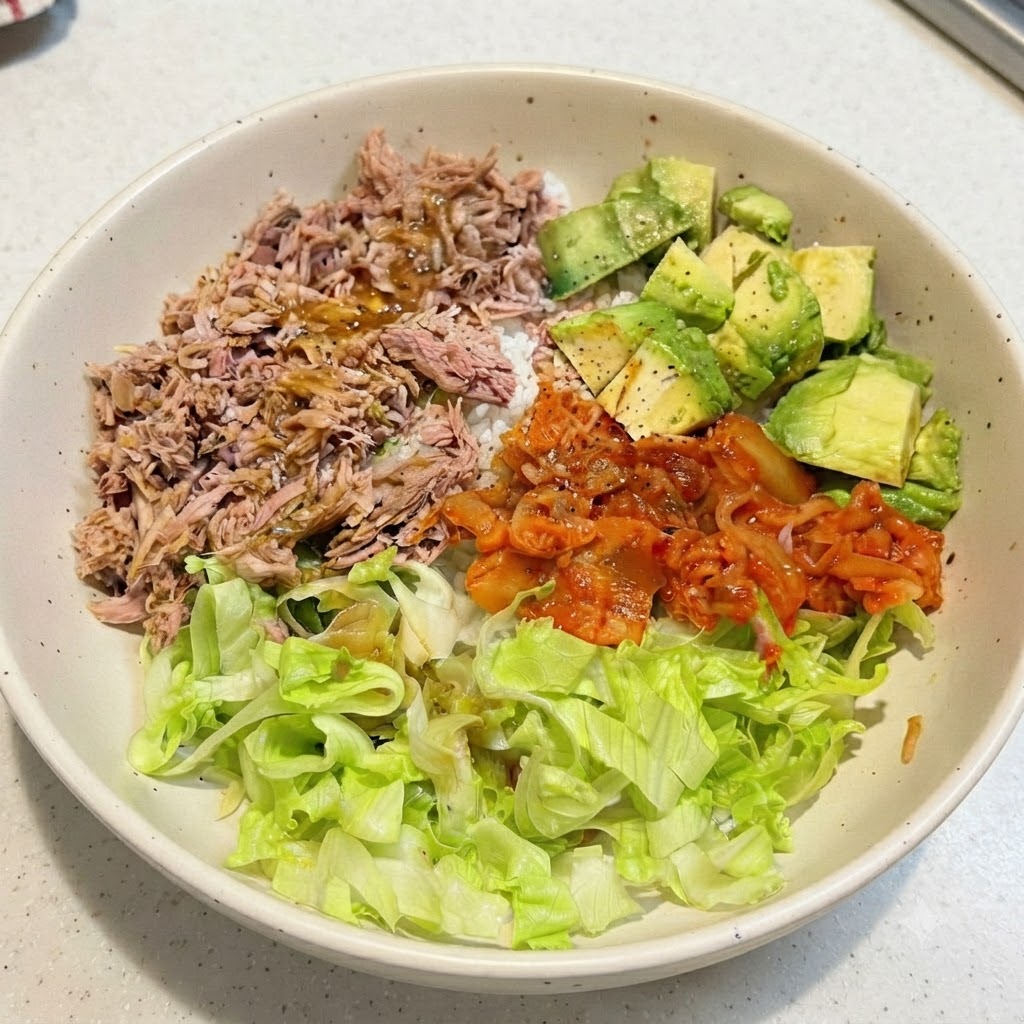 用意された具材の上にドレッシングが回しかけられた、完成したツナアボカド丼。