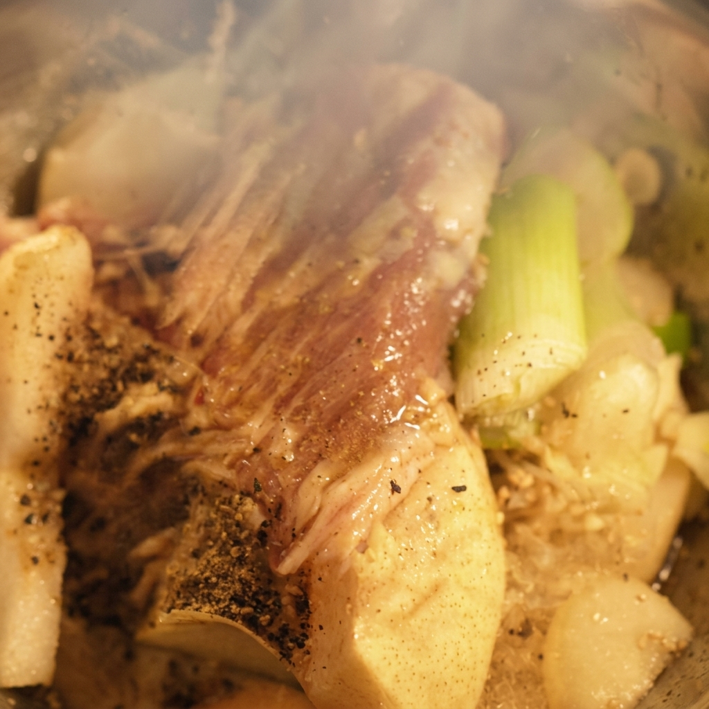 ブレンダー内の材料の上から、液体調味料が注がれている様子。