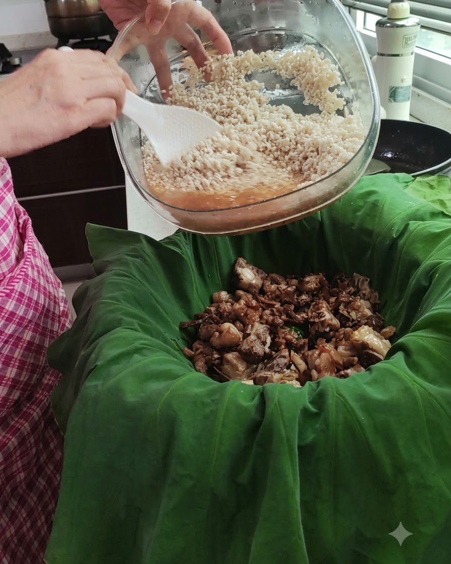 ガラスボウルに入った浸水米を、蓮の葉の中にある豚肉の上に流し込んでいる様子。