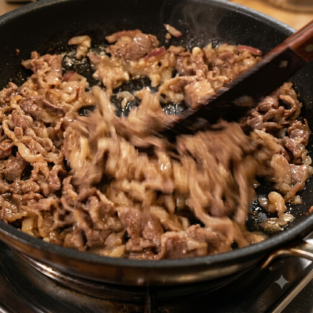牛肉や玉ねぎと一緒に刻んだ乾燥赤唐辛子をフライパンで炒めている様子。