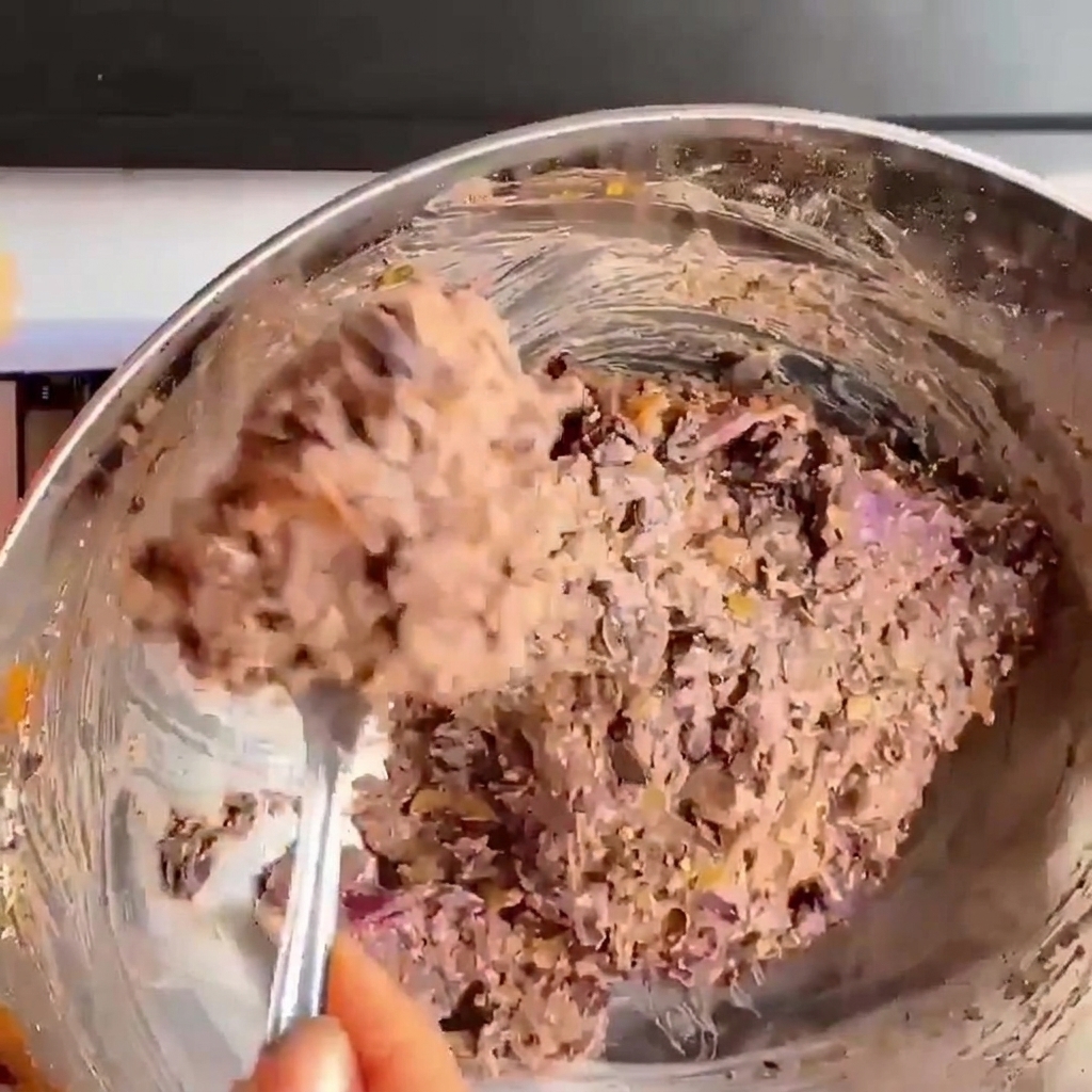 黒インゲン豆の生地を両手で丸く押し固めてバーガーパティを作っている手元