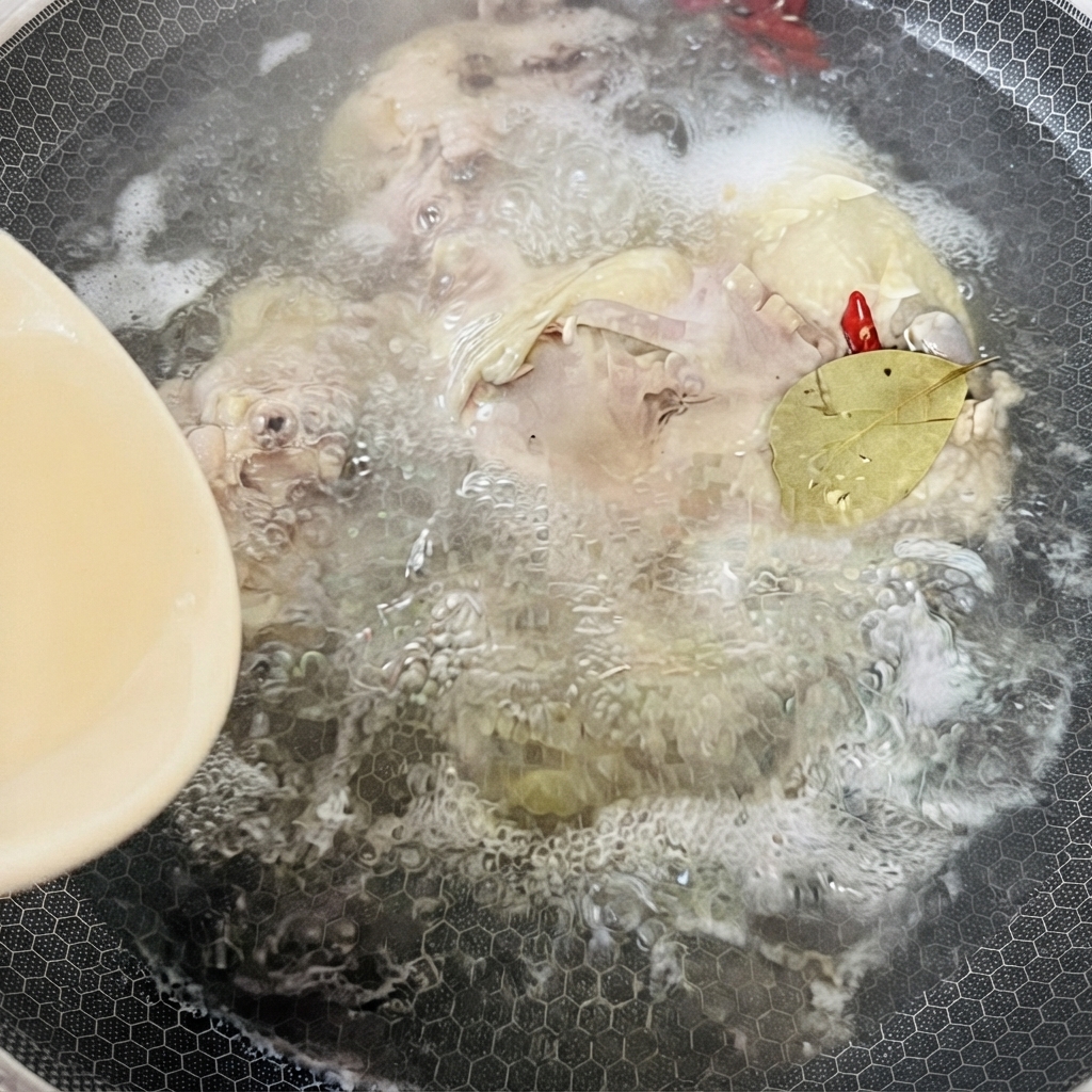 鶏ガラスープ、スパイス、ローリエが入り、熱で煮込まれている鍋。