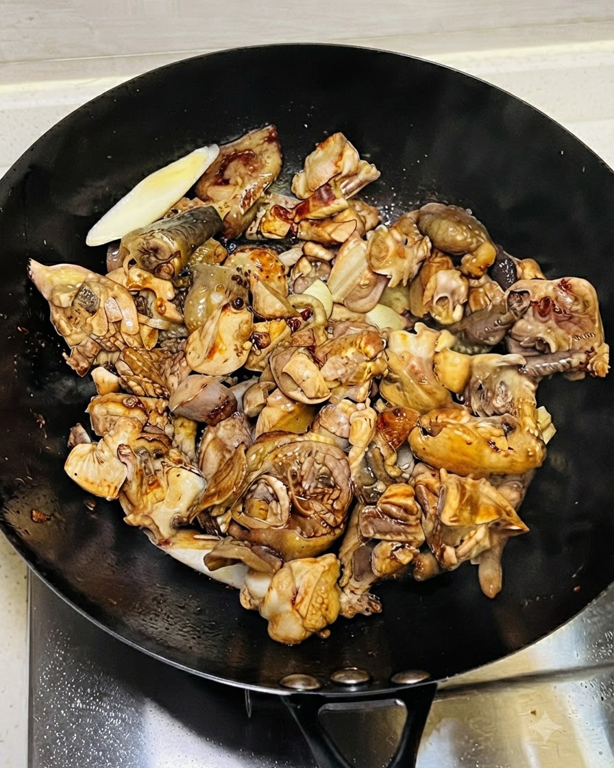 鶏肉の上から薄口醤油や濃口醤油などの調味料を回し入れている様子。