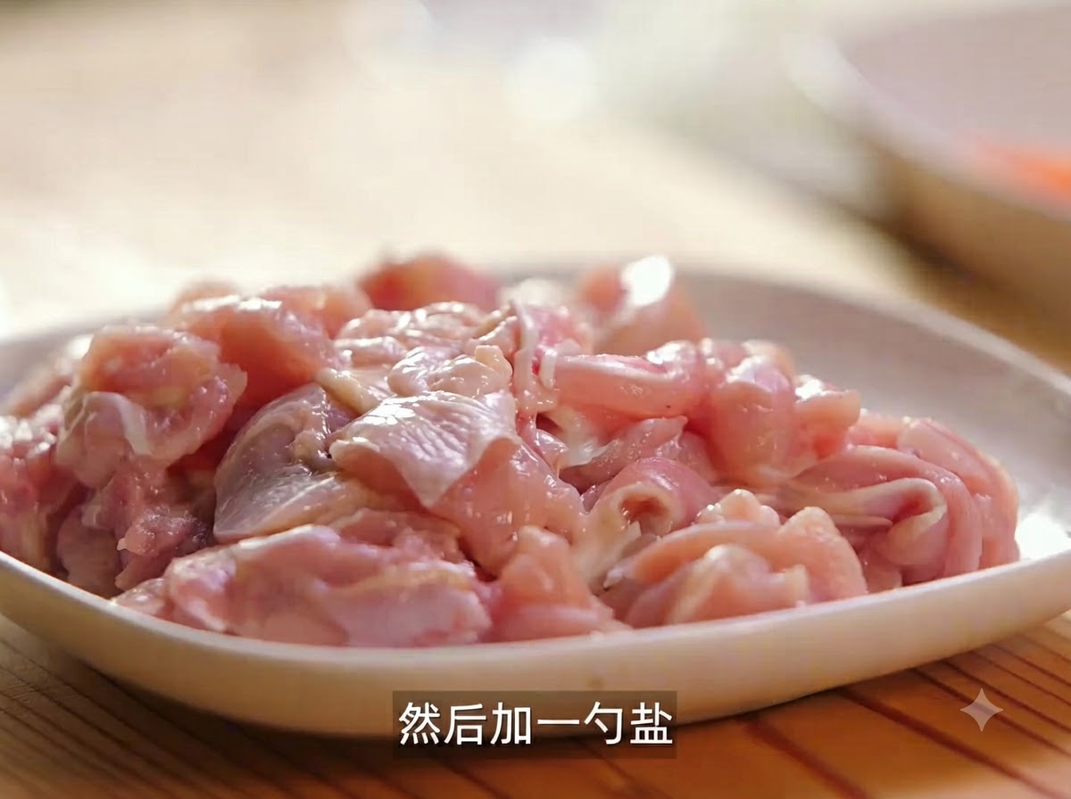 塩と黒こしょうで下味をつけ、調理待ちの生鶏肉のカットが皿に盛られている様子。