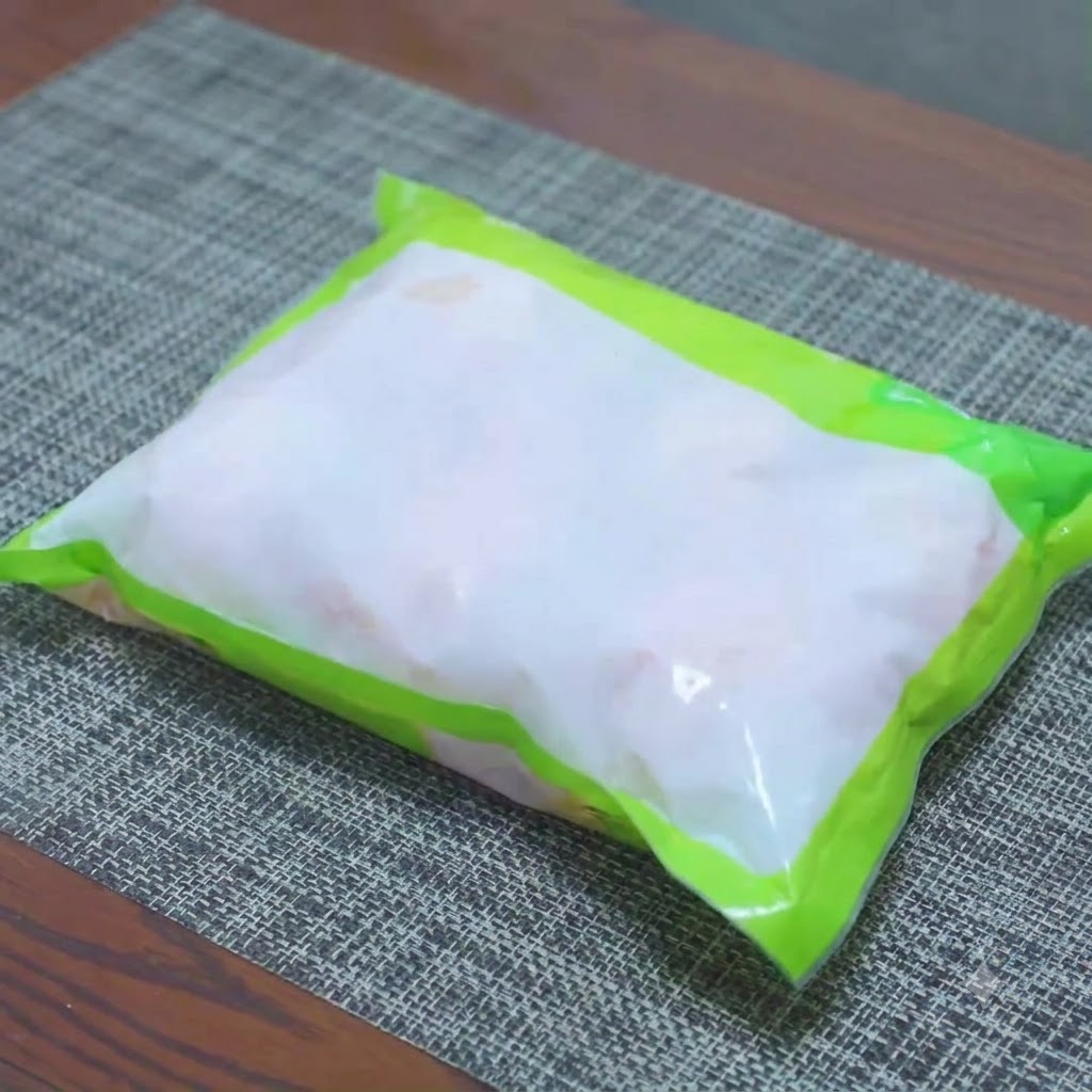 少量の塩を加えたボウルの中で急速解凍されている冷凍の鶏もも肉。