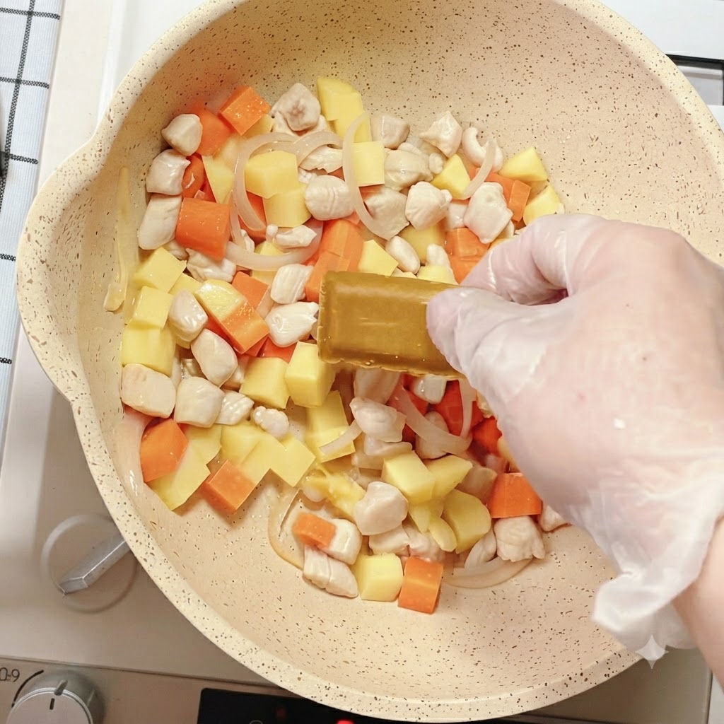 具材の入ったフライパンの中に、カレールーを置いている様子。