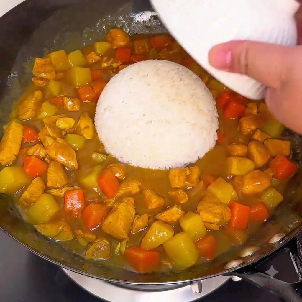 中華鍋の中のとろみのあるカレーソースに、白ご飯を入れた大きなお椀をひっくり返して合わせている様子。