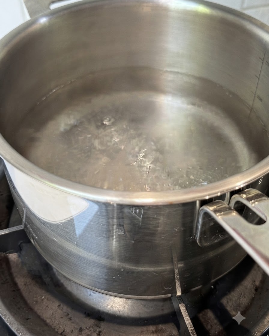 沸騰したお湯の入った鍋に乾燥スパゲッティの麺が垂直に入れられている様子。