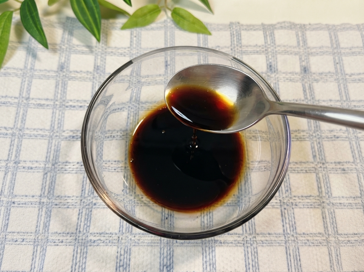 ガラスボウルの中で醤油やその他の調味料が水と一緒に混ぜ合わされている様子。