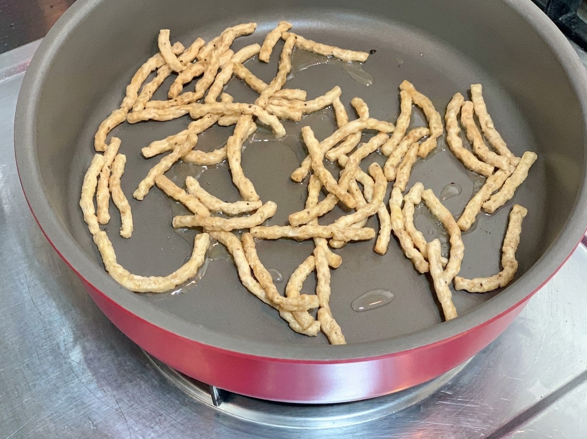 少量の油を引いた熱したフライパンで大豆ミートを炒めている様子。