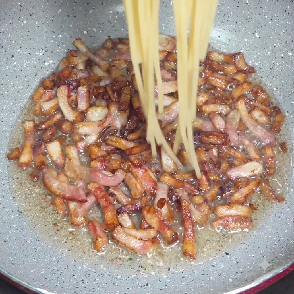 トングを使って、ゆであがったスパゲッティを、カリカリのグアンチャーレが入ったフライパンに移している様子。