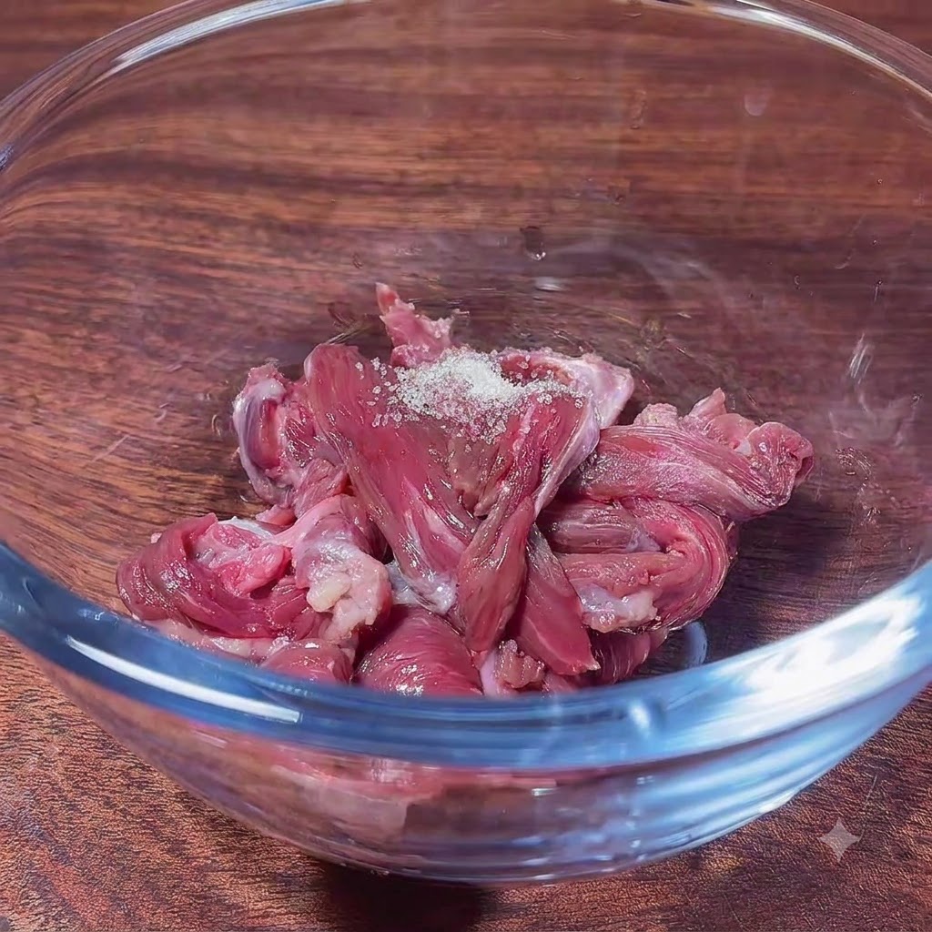 砂糖などの調味料をのせた生の薄切り牛肉が入ったガラスボウル