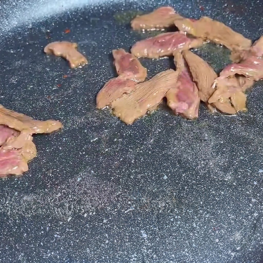 フライパンで牛肉の薄切りを炒めている様子