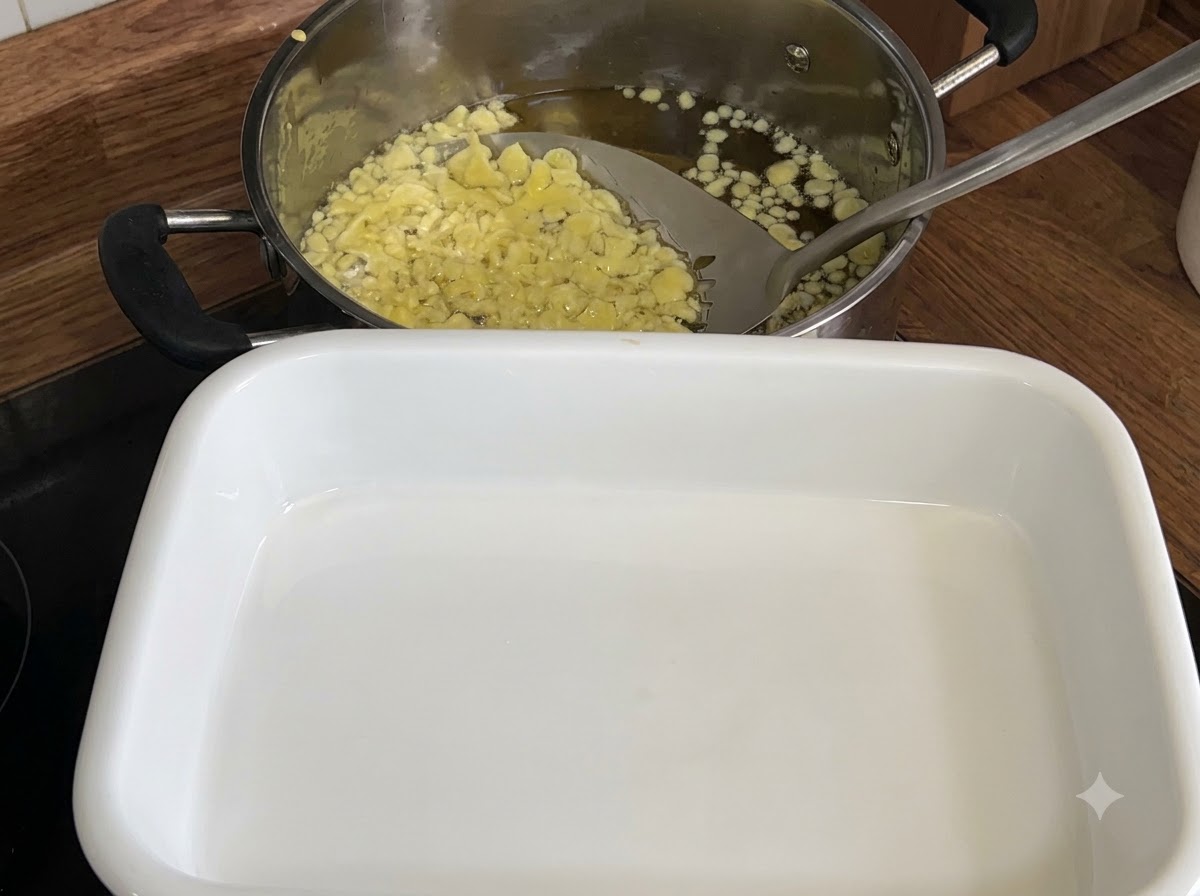 穴あきお玉を使って、油の中からきつね色の天かすをすくい取っている様子。