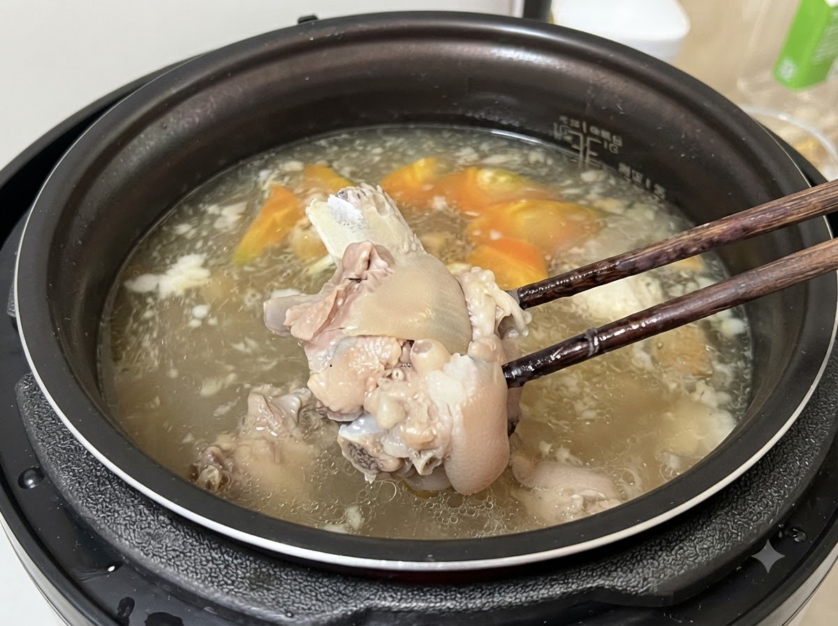 箸で煮込まれた柔らかい肉をスープから持ち上げている様子。
