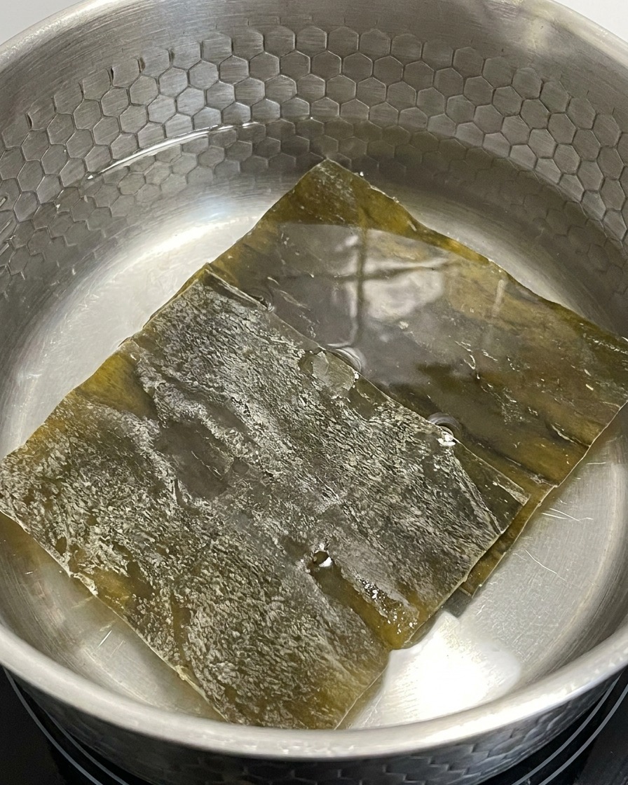 弱火にかけた鍋の水に乾燥昆布を浸している様子。