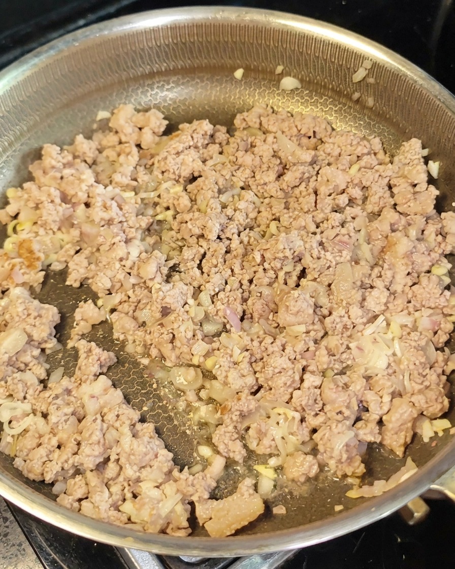 炒められたひき肉と野菜に赤味噌を混ぜ合わせている様子