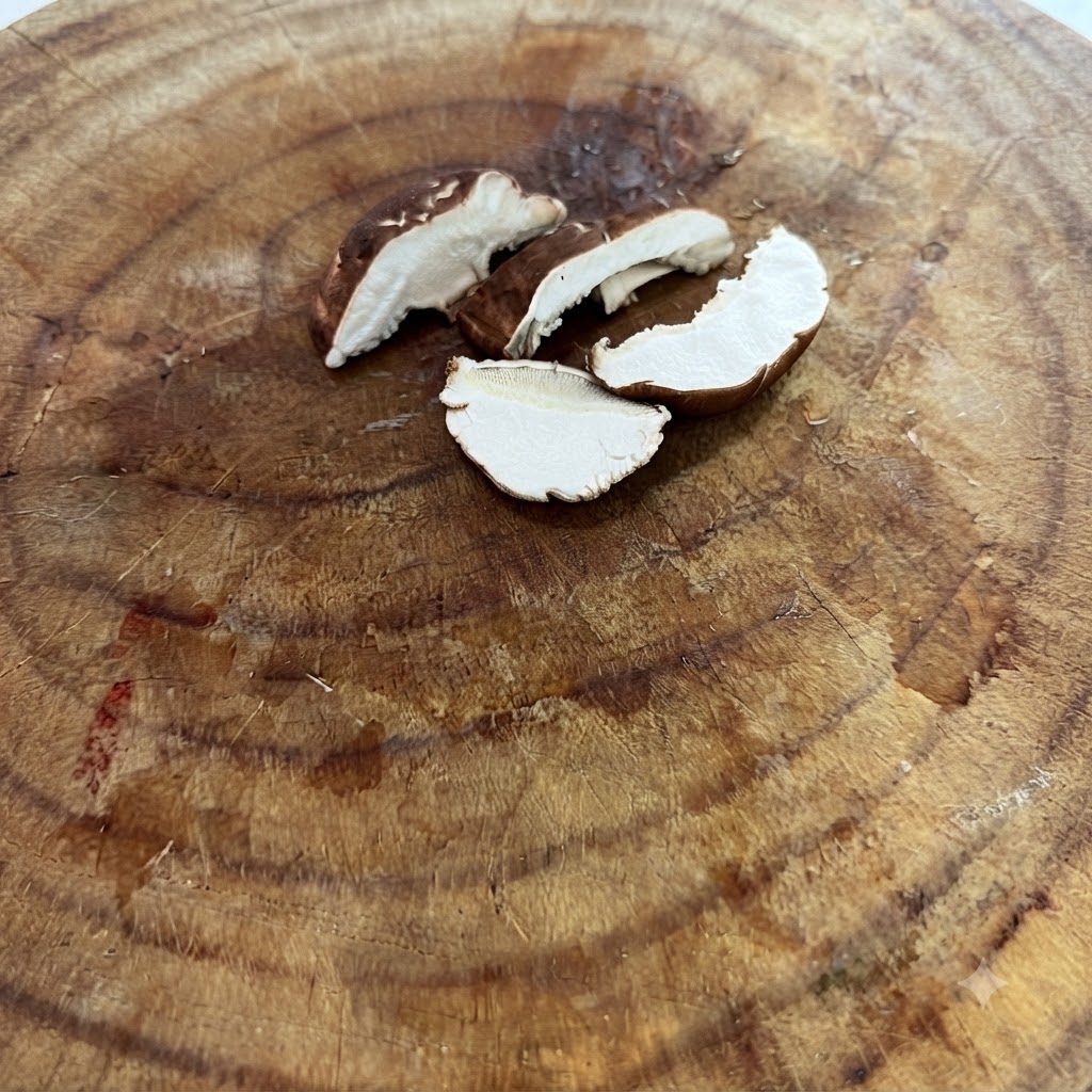 木製のまな板の上に置かれた、薄切りにされた生シイタケ。