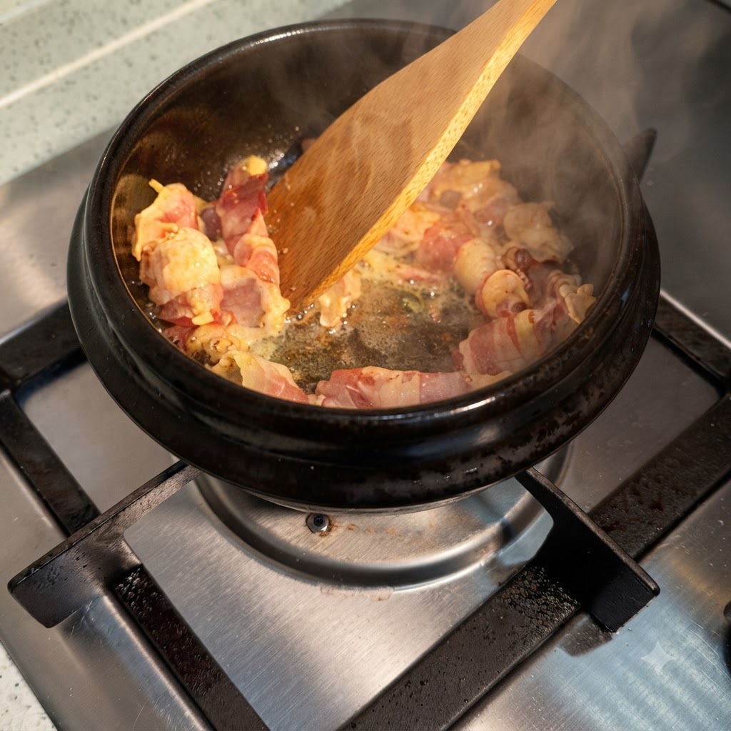 熱した鍋の中でジュージューと焼ける牛肉に醤油を回しかけ、湯気が立っている様子。