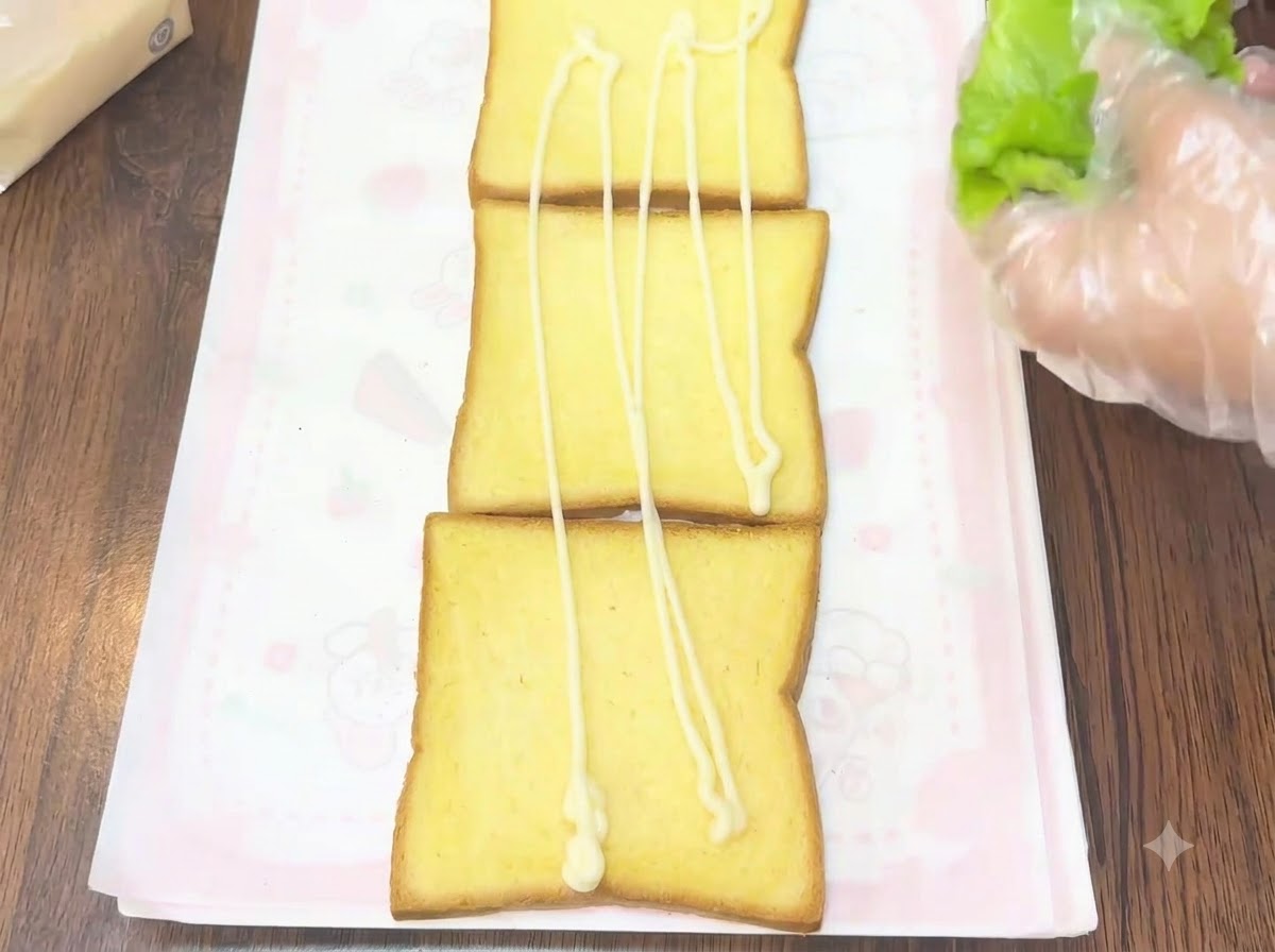 ドレッシングを塗ったトーストに新鮮なレタスを乗せている様子。