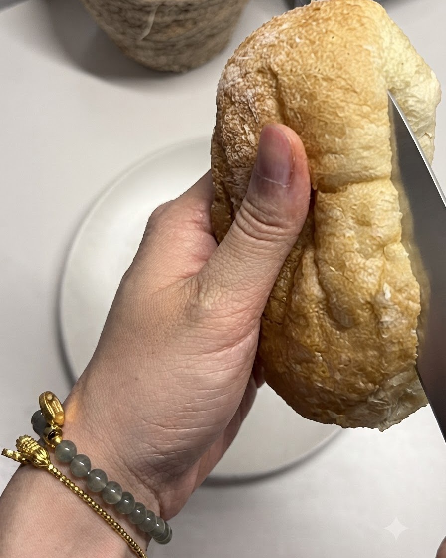 ナイフでチャバタパンをスライスして開いている様子。