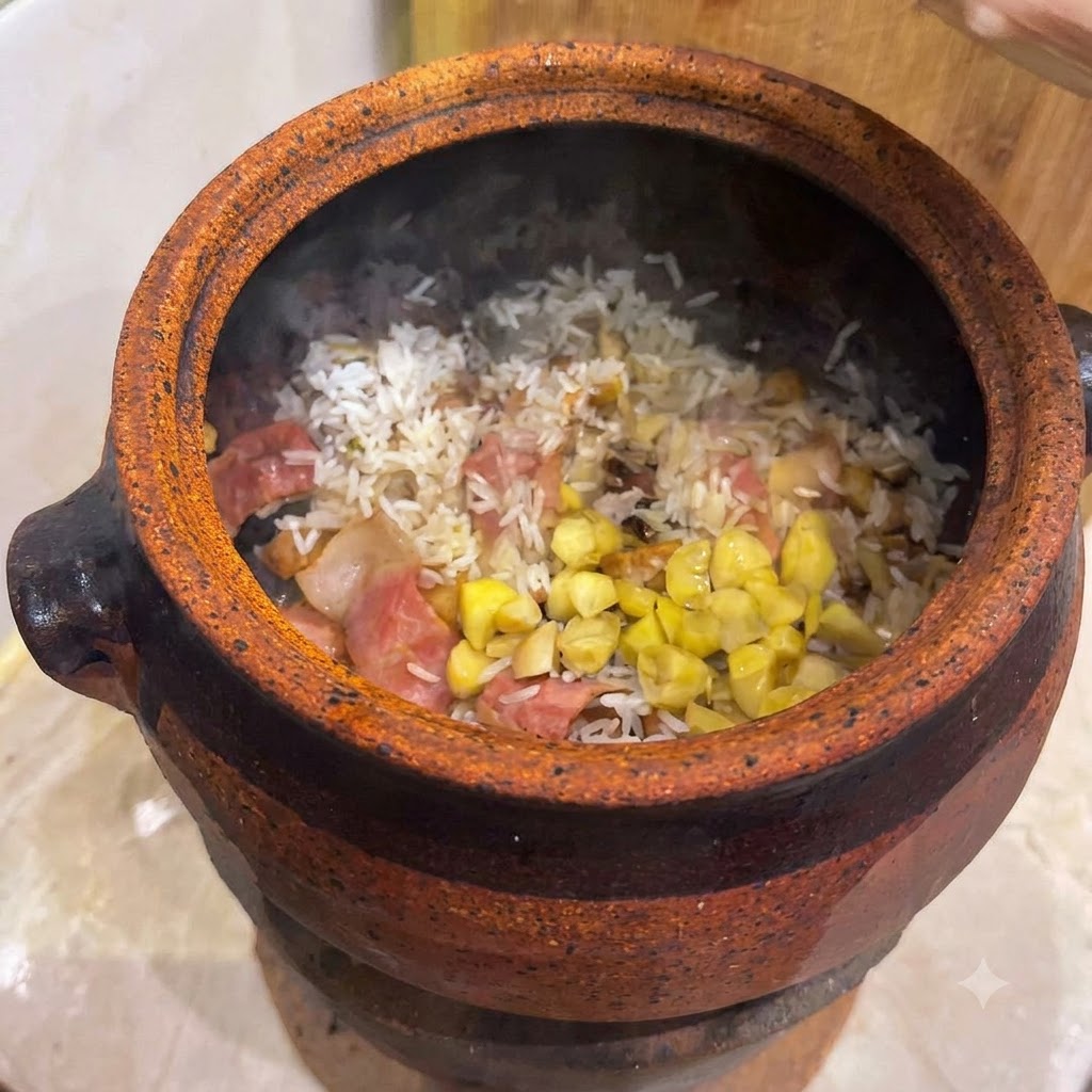 土鍋の中の混ぜ合わせたご飯とベーコンの上に散りばめられた銀杏と黄色の栗の欠片。