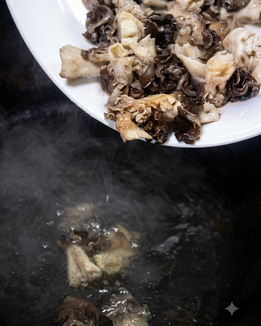 白い皿から下準備したキノコを沸騰したお湯の鍋に入れている様子。