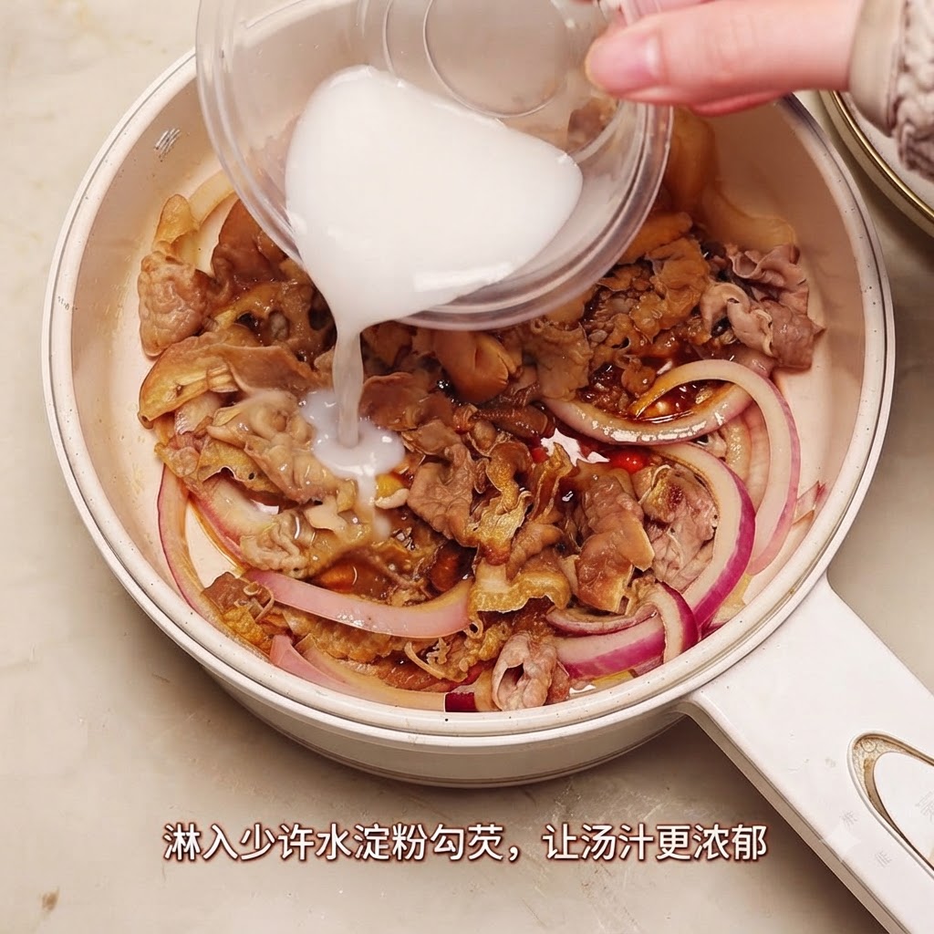 煮込んでいる牛肉と玉ねぎのフライパンに、小さな容器から水溶き片栗粉が注がれている様子。