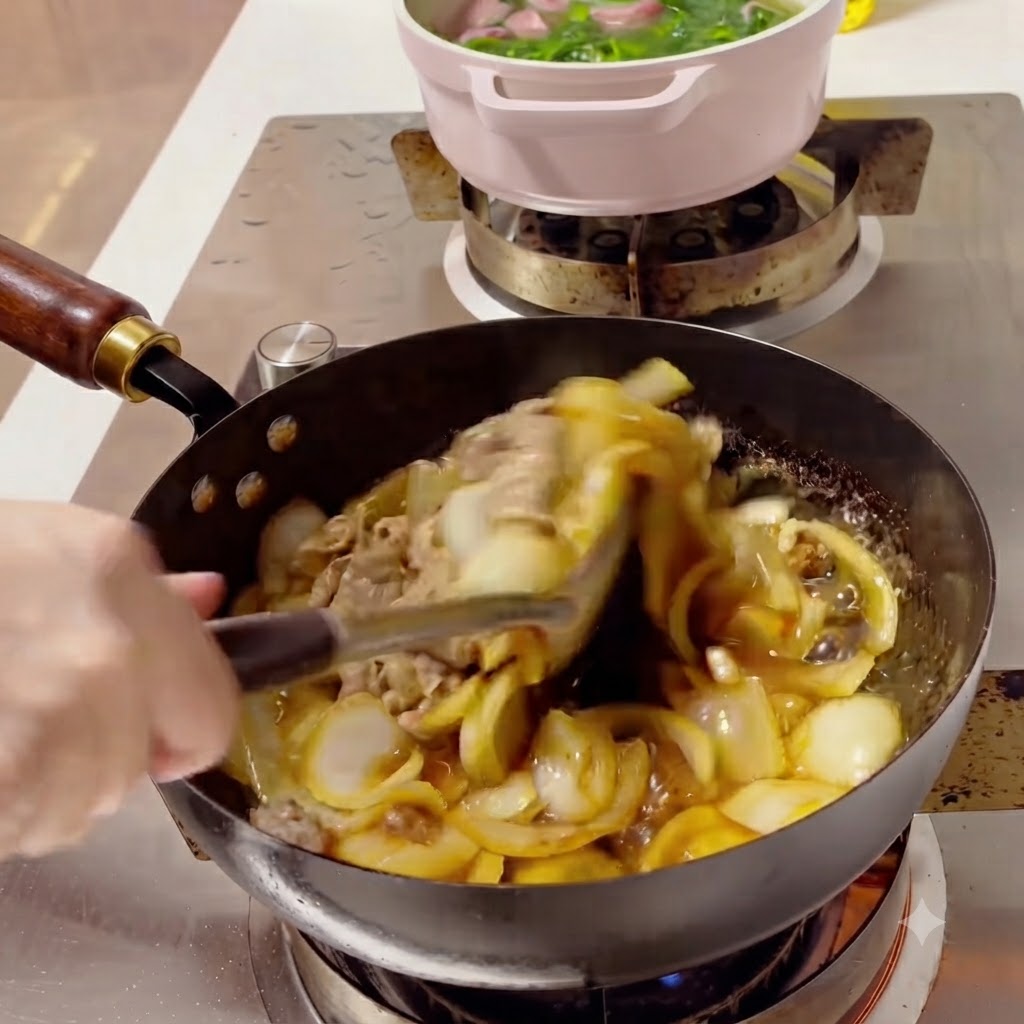 濃厚でとろみのあるタレの中で中華鍋の中一緒に和えられる牛肉とタマネギ。