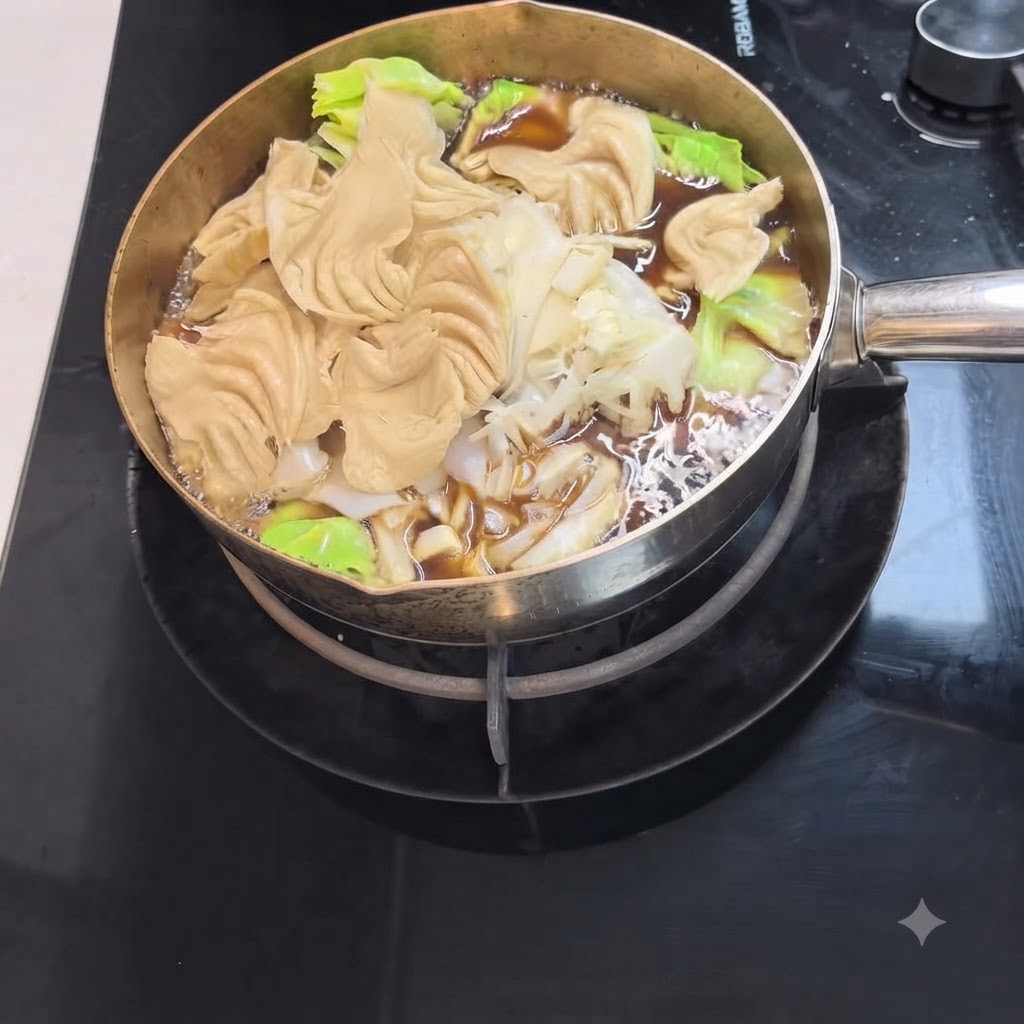 色の濃いすき焼きスープの中で、うどんの麺と新鮮な葉物野菜が煮込まれている様子。