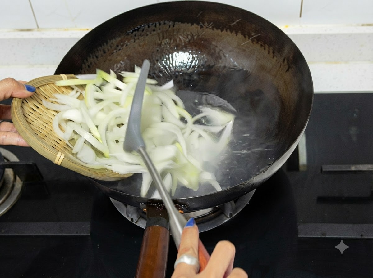 熱した中華鍋に木のお盆からスライスした玉ねぎを入れている様子。