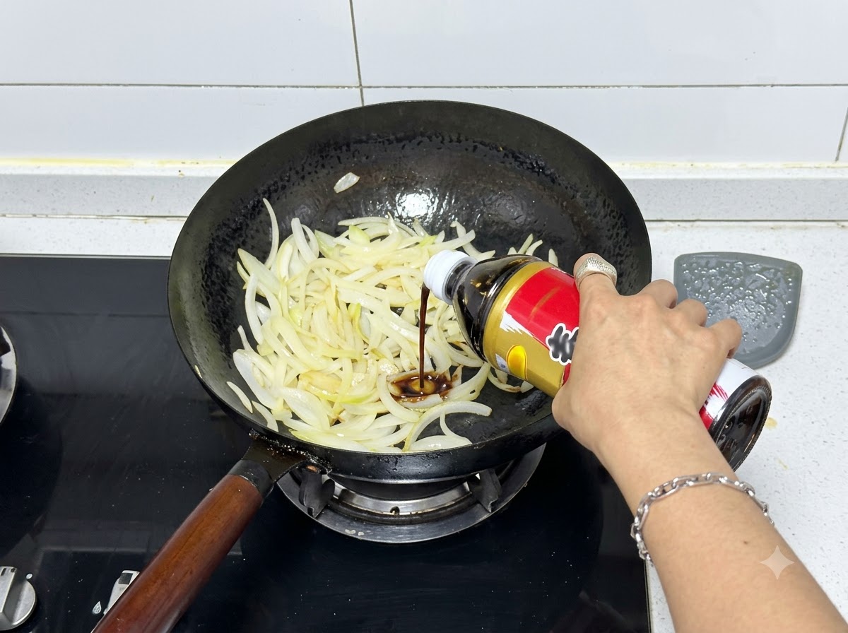 炒めた玉ねぎの入った中華鍋にボトルからすき焼きのたれを注ぐ様子。