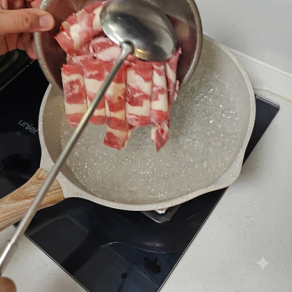 沸騰したお湯の入った鍋に、金属製のおたまを使って薄切り牛肉を入れている様子