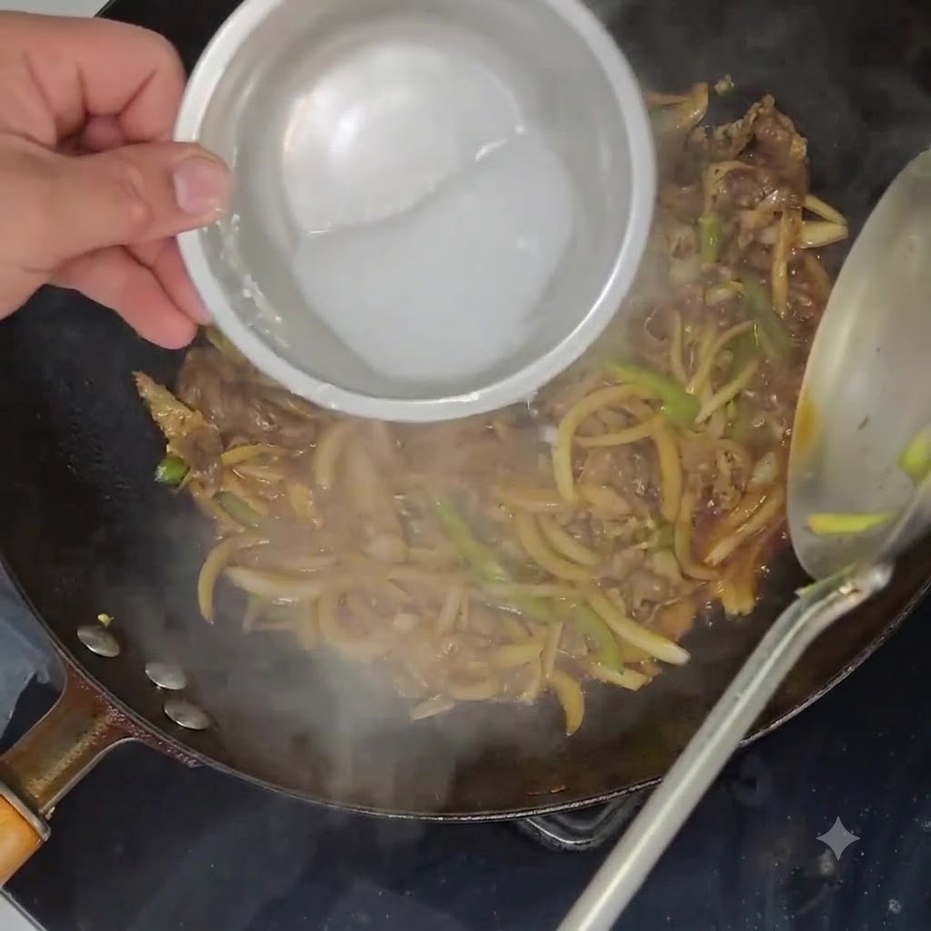 牛肉と野菜が煮込まれた中華鍋に、小さなボウルに入れた水溶き片栗粉を回し入れている様子