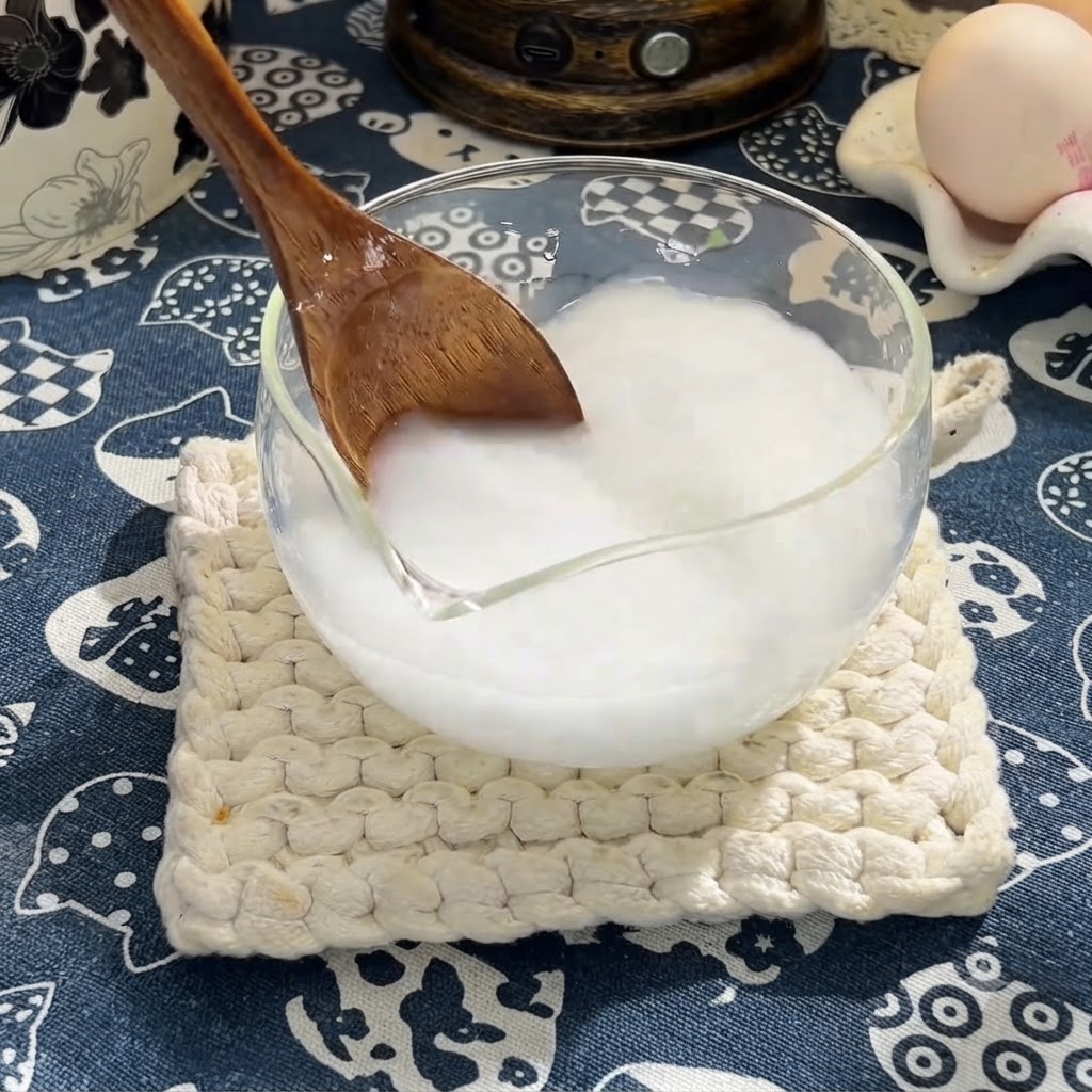 木べらを使って、片栗粉の入った混合液に醤油、オイスターソース、はちみつを混ぜ合わせている様子
