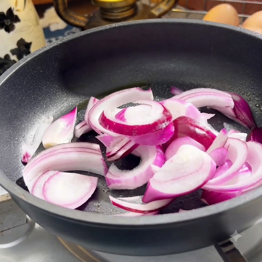 フライパンで赤玉ねぎと牛肉のスライスを一緒に炒めている様子