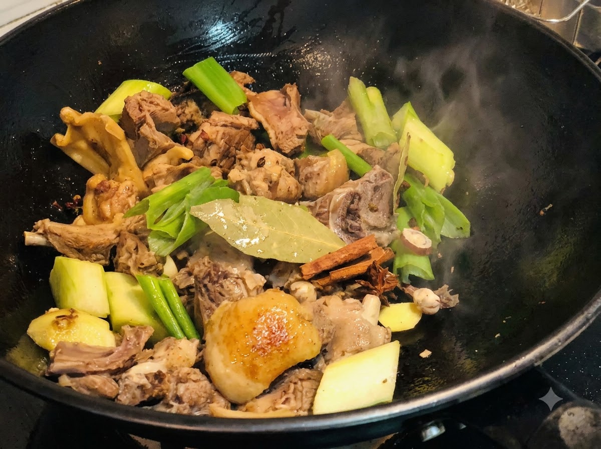八角、ローリエ、シナモンスティックなどのホールスパイスが、中華鍋の鴨肉や香味野菜と混ぜ合わされている様子。